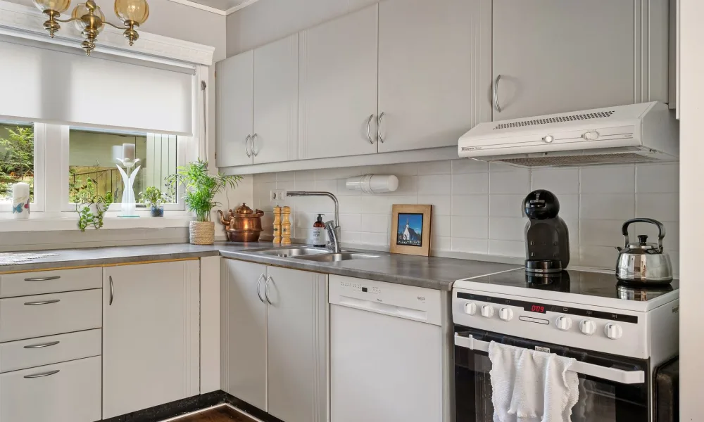 portable ice maker on narrow apartment kitchen counter near sink