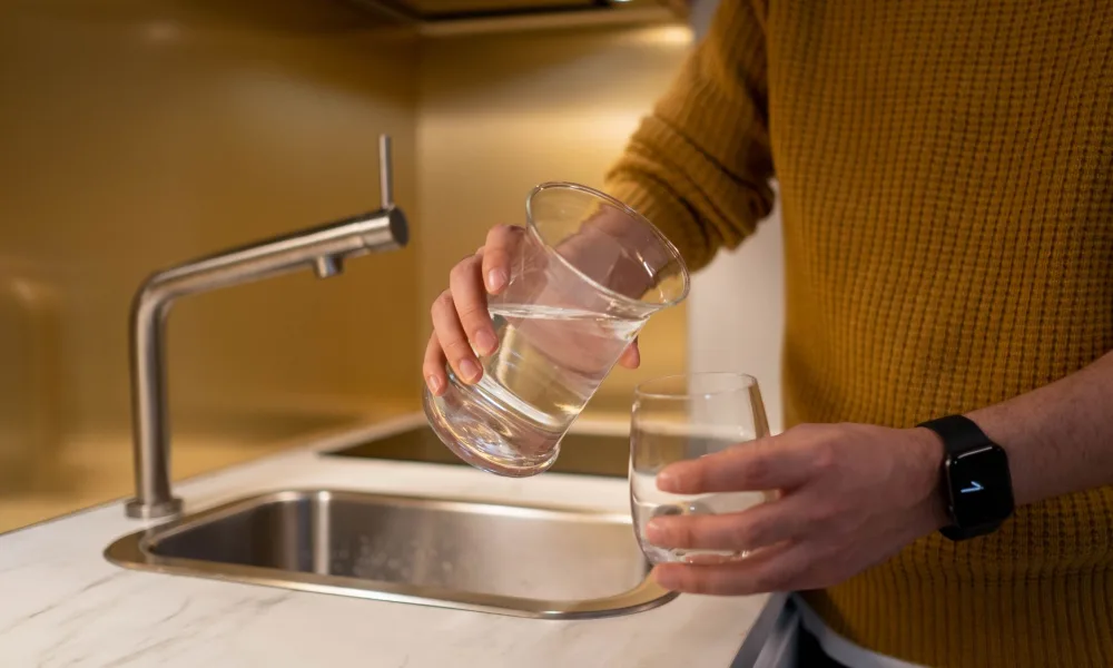 pouring filtered water into countertop ice maker tank