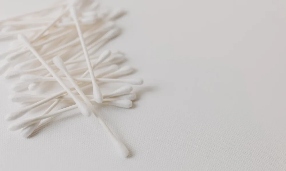 cotton swab cleaning small metal water level sensor inside ice maker