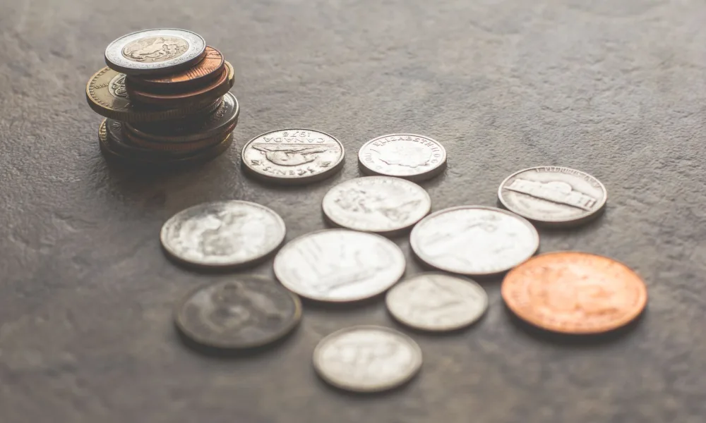receipts and coins stacked next to a countertop ice maker