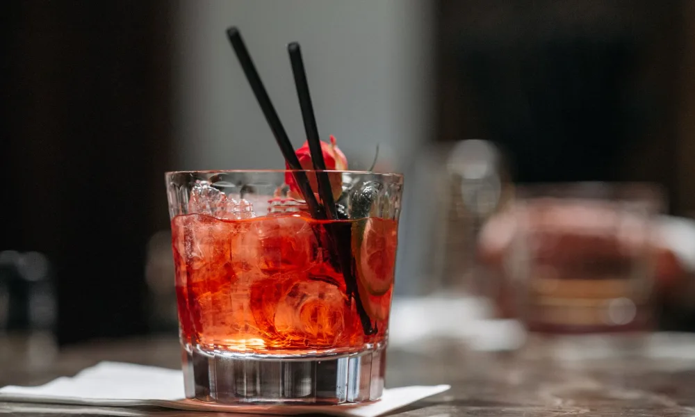 cocktail with large clear ice cube in tumbler