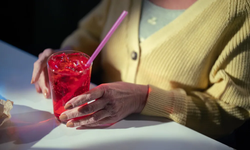 person chewing soft nugget ice from a glass