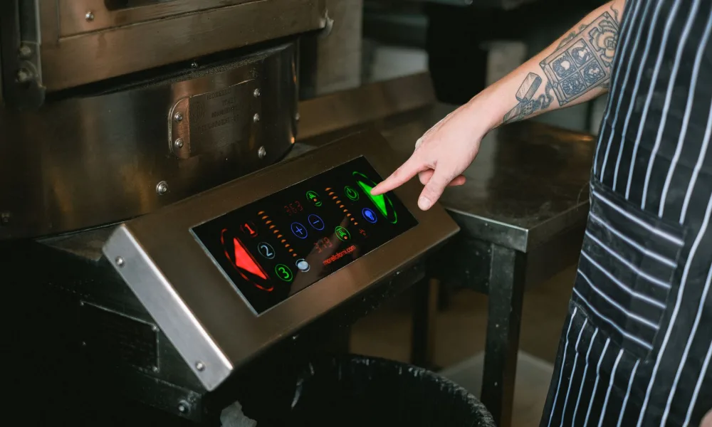 hand pressing and holding reset button on ice maker control panel