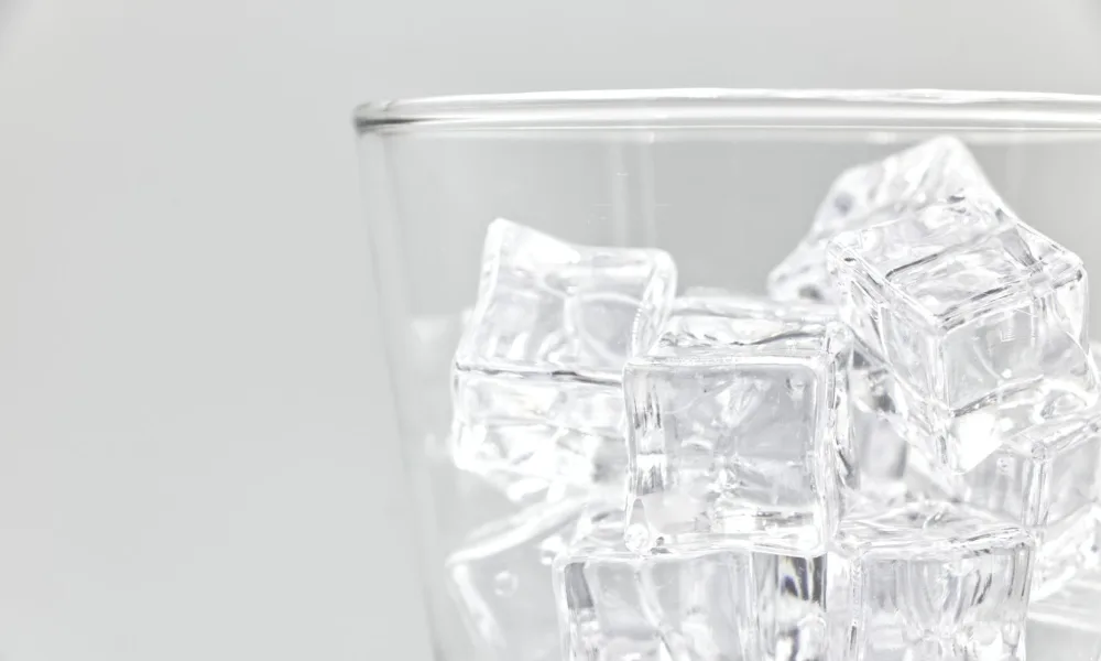 clumped ice cubes frozen into a block in bin